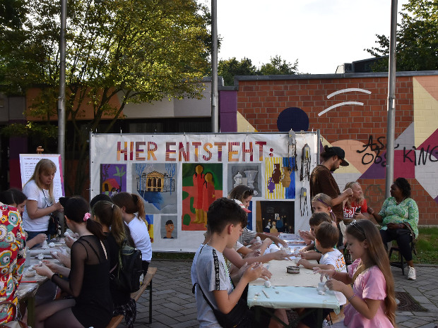 Viele Personen sitzen an zwei langen Tischen