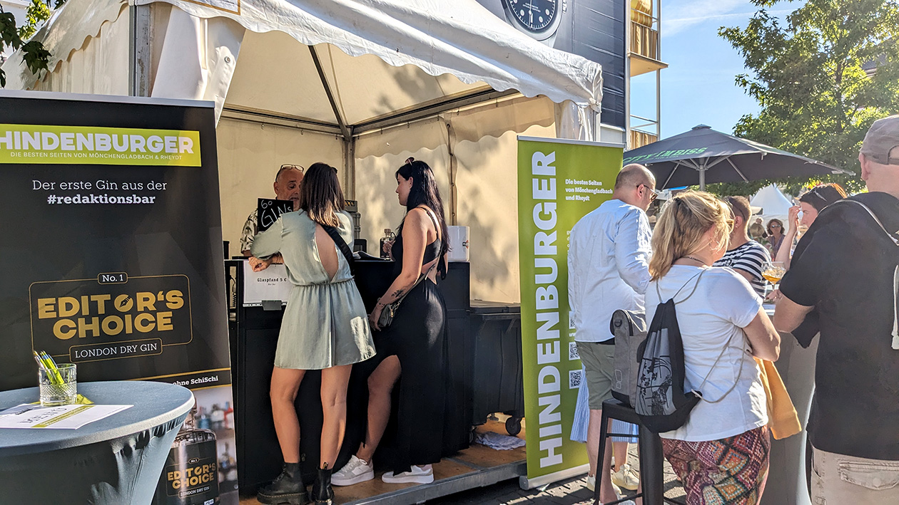 Mehrere Personen stehen an der Redaktionsbar und Trinken Gin-Tonic