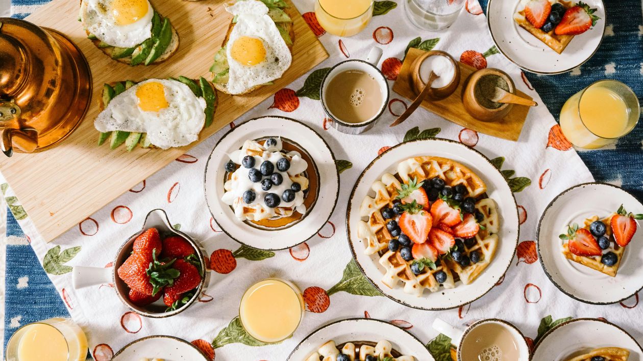 Viele Teller serviert Mit Waffeln, frischem Obst und Saft