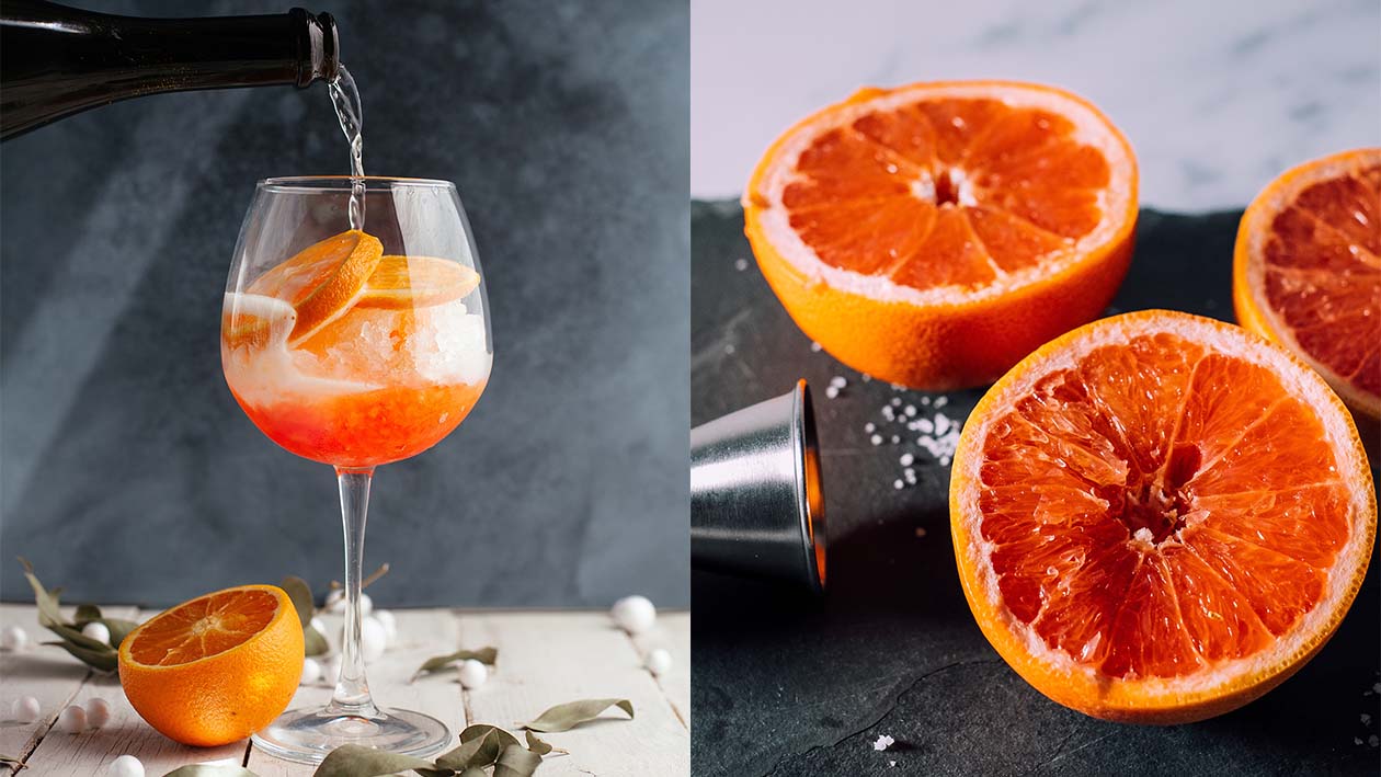 Oranger Drink mit Orangenscheiben und Eis, Halbierte Blutorangen