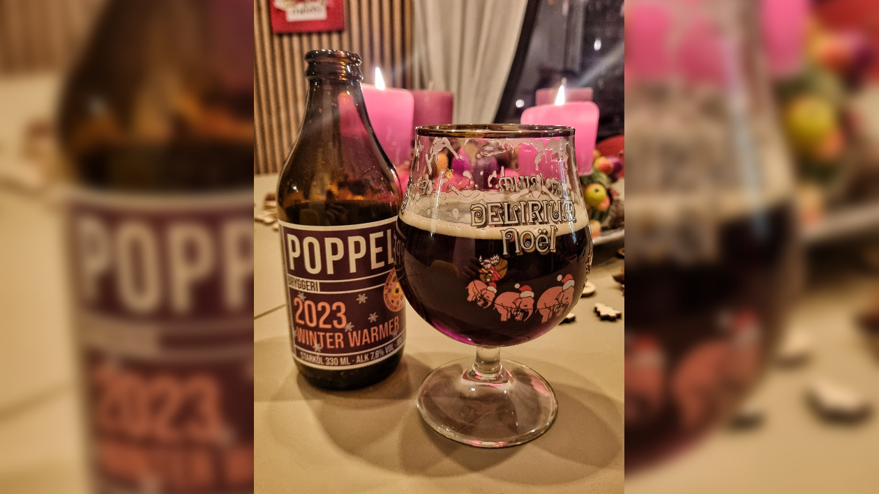 Eine Flasche Winter Warmer der Brauerei Poppels, daneben ein gefülltes Bierglas