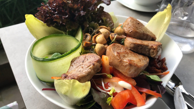 Ein bunter Salatteller mit Fleisch, Paprika, Pilzen, Gurke und anderem Gemüse