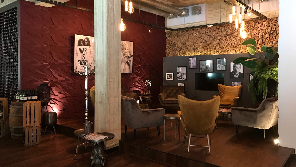 Die Lounge-Ecke des Restaurant ninetynine mit gemütlichen Sitzgelegenheiten, an den Wänden hängen große schwarz-weiß Bilder