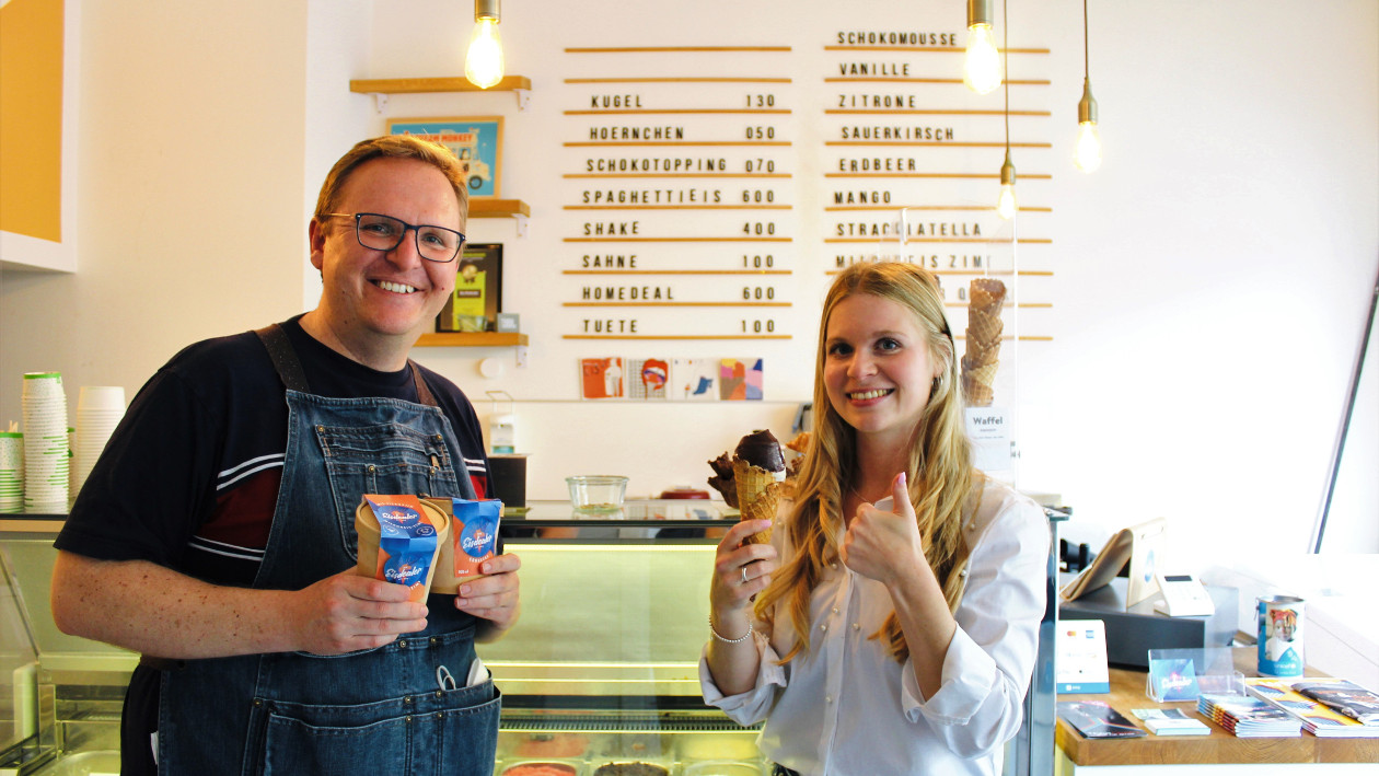 Gründer und „Eisdealer“ Michael Bahrke und Hindenburger-Redakteurin Jessica Sindermann stehen in der Eisdiele "Die Eisdealer"