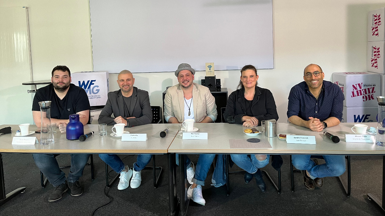 Sinan Heesen, Frank Klix, Tim Kramer, Sandra Züwerink und Wasilli Theis sitzen an einem langen Tisch nebeneinander.