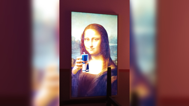 Ein Bild an einer Wand, darauf zu sehen ist die Mona Lisa, sie hält eine RedBull Dose in der Hand