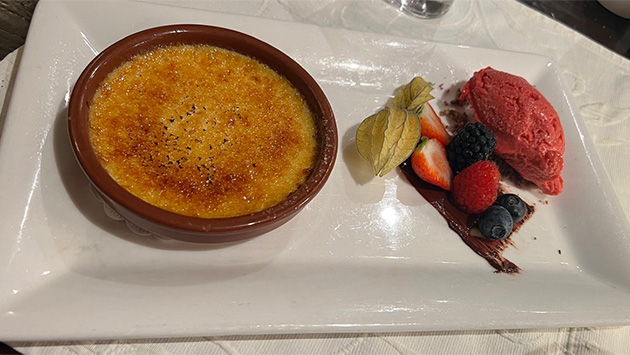 Crème brûlée mit Himbeersorbet serviert auf einem Teller