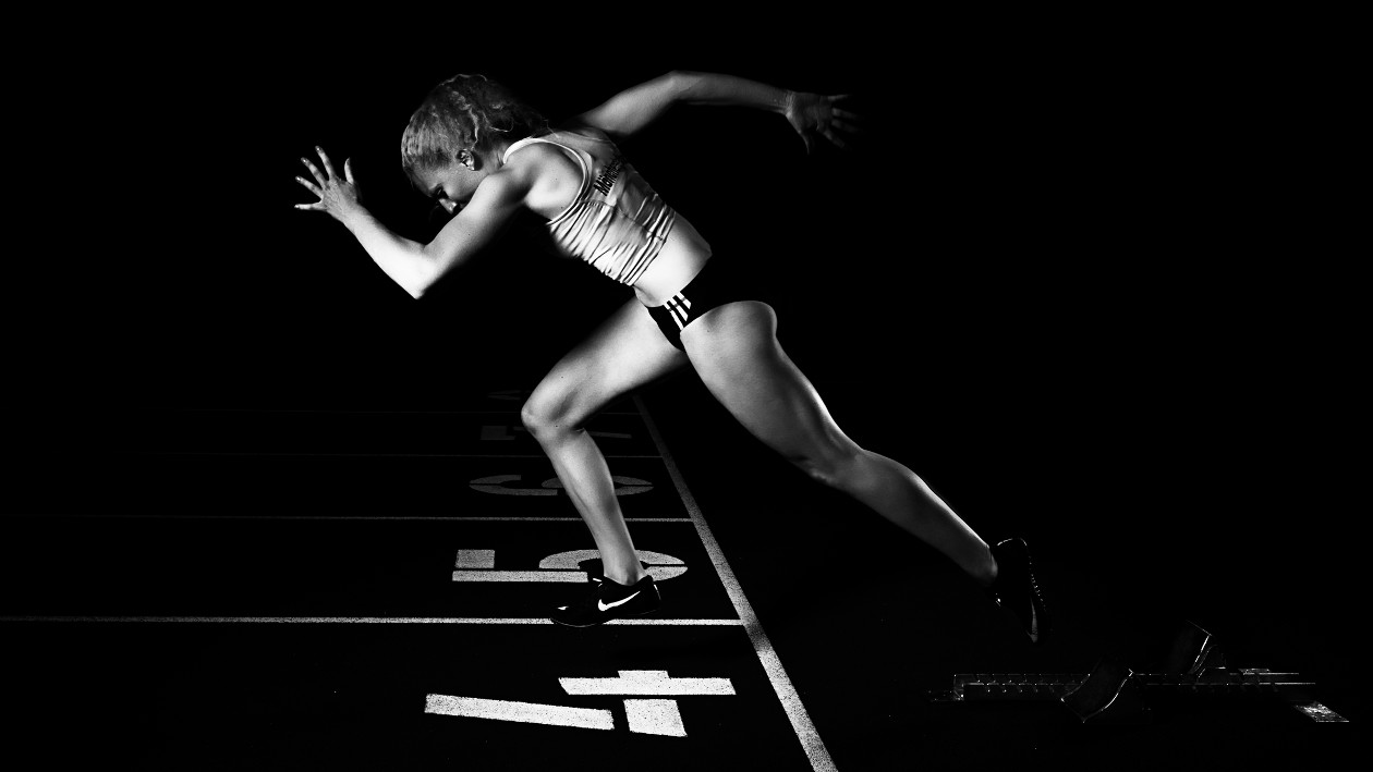 Eine schwarz-weiß Aufnahme einer Sportlerin, das Licht schafft hohe Kontraste