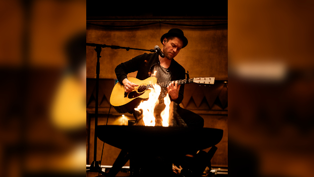 Johannes Oerding mit Akustikgitarre, im Vordergrund ein Lagerfeuer