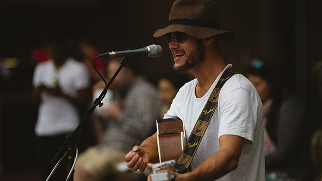 Eine person spielt Akustikgitarre und singt dabei