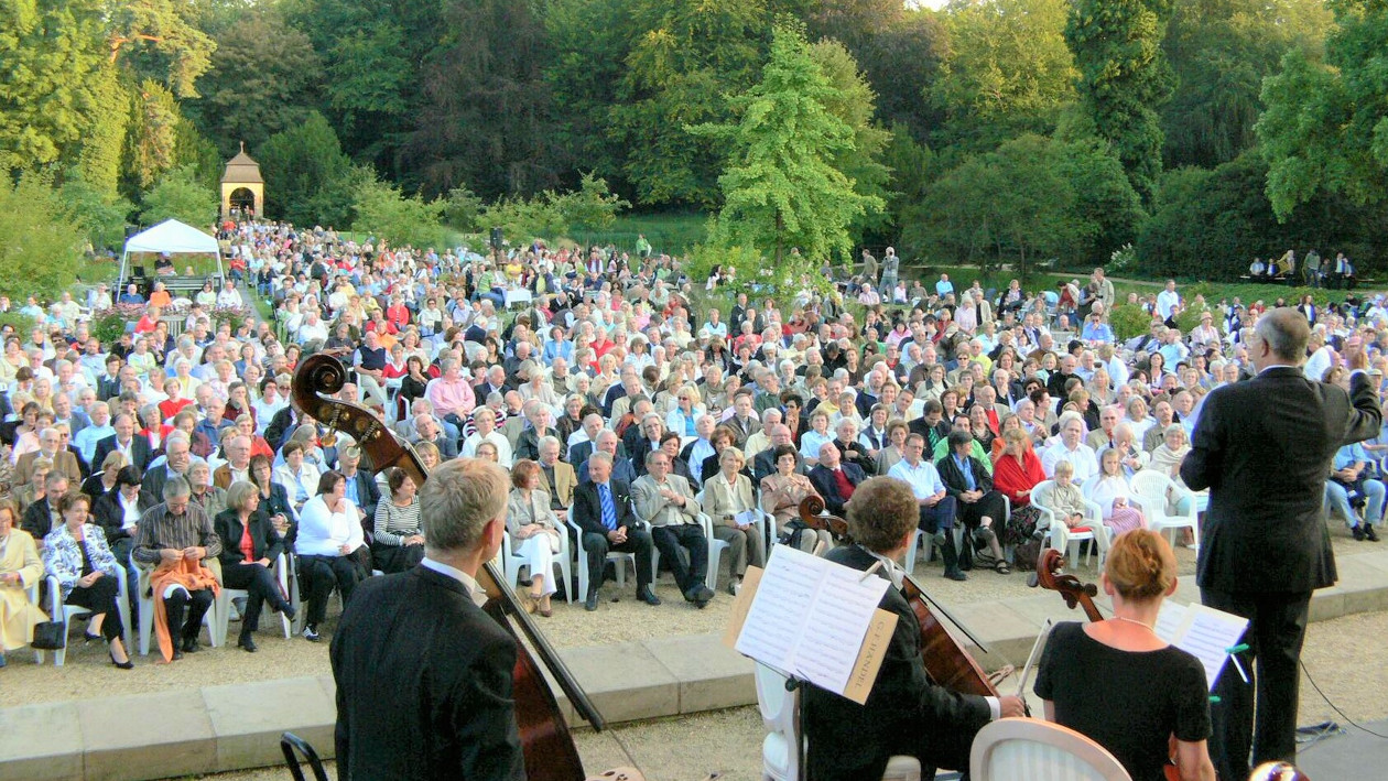 Ein Ensemble steht auf einer Bühne, vor der Bühne sind viele Zuschauer