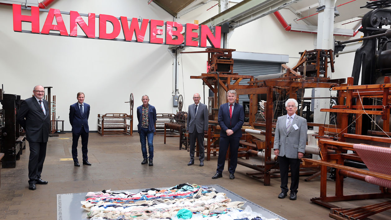 Der Vorstand des TextilTechnikums vor historischen Textilmaschinen und Farbstoffsammlung