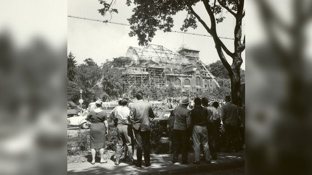 Ein altes schwarz-weiß Foto von Mönchengladbach aus den 50ern oder 60ern. Menschen beobachten ein brennendes Gebäude.