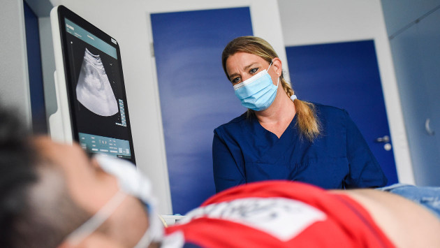 Dr. Med. Ines Wissussek steht vor einem liegenden Patienten