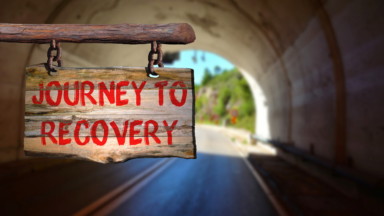 Ein Schild mit der Aufschrift "Journey to recovery", im Hintergrund ein Tunnel