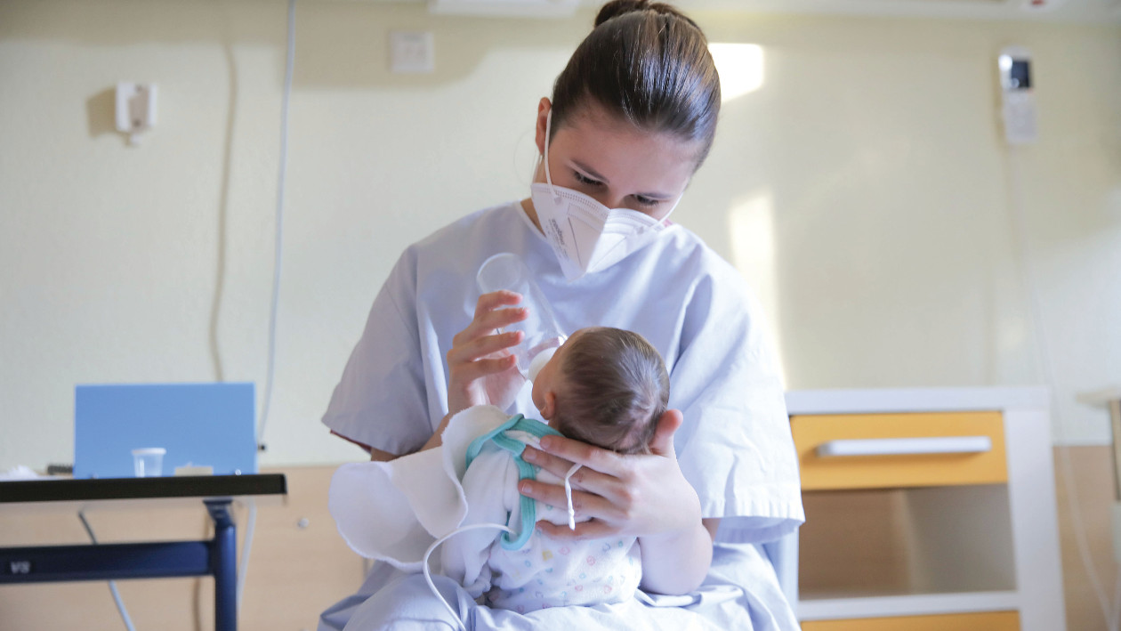 Eine Auszubildende der Kinder- und Jugendklinik der Städtischen Kliniken Mönchengladbach füttert ein Säugling mit Flasche.