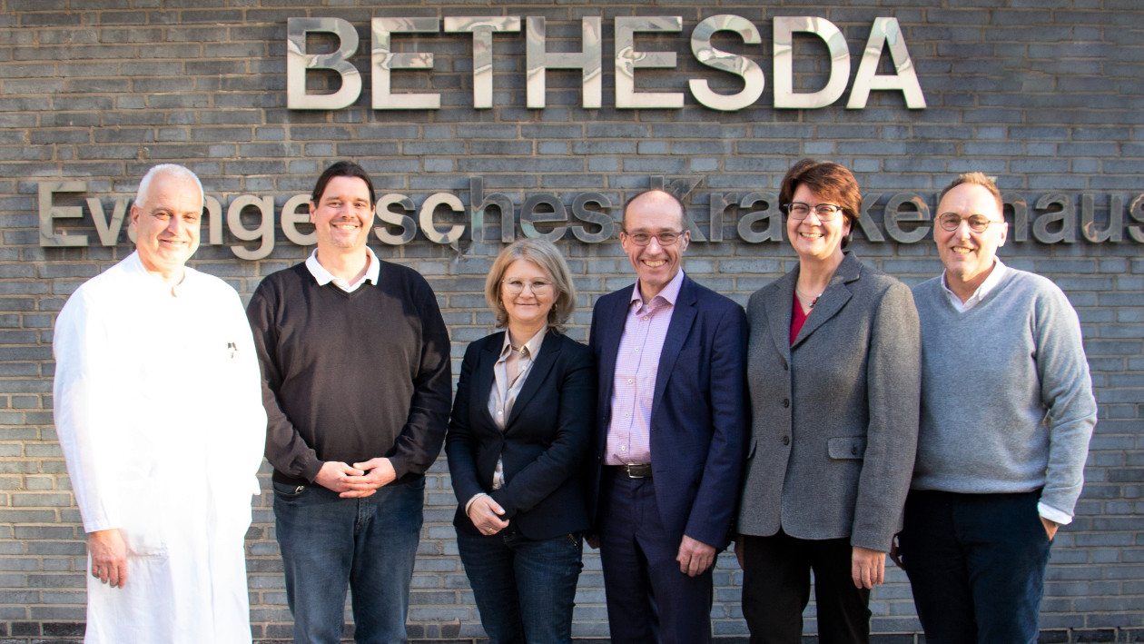 Dr. Andreas Tittel, Markus Pressentin, Dr. Ljiljana Joksimovic, Dorothee Enbergs und Jochen Möller stehen draußen vor dem Logo des Bethesda Krankenhauses in Mönchengladbach