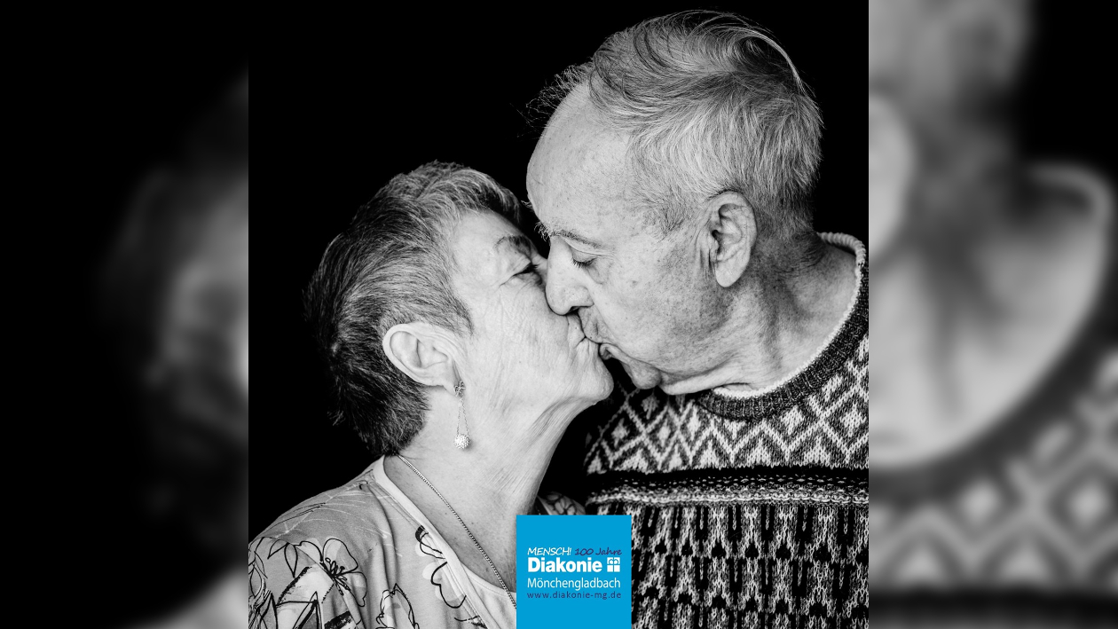 Eine schwarz weiß Aufnahme eines sich küssenden Seniorenpaars