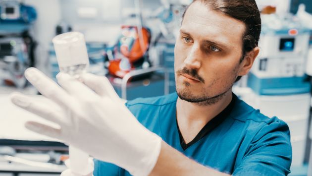 Ein Mitarbeiter im Krankenhaus zieht eine Spritze auf