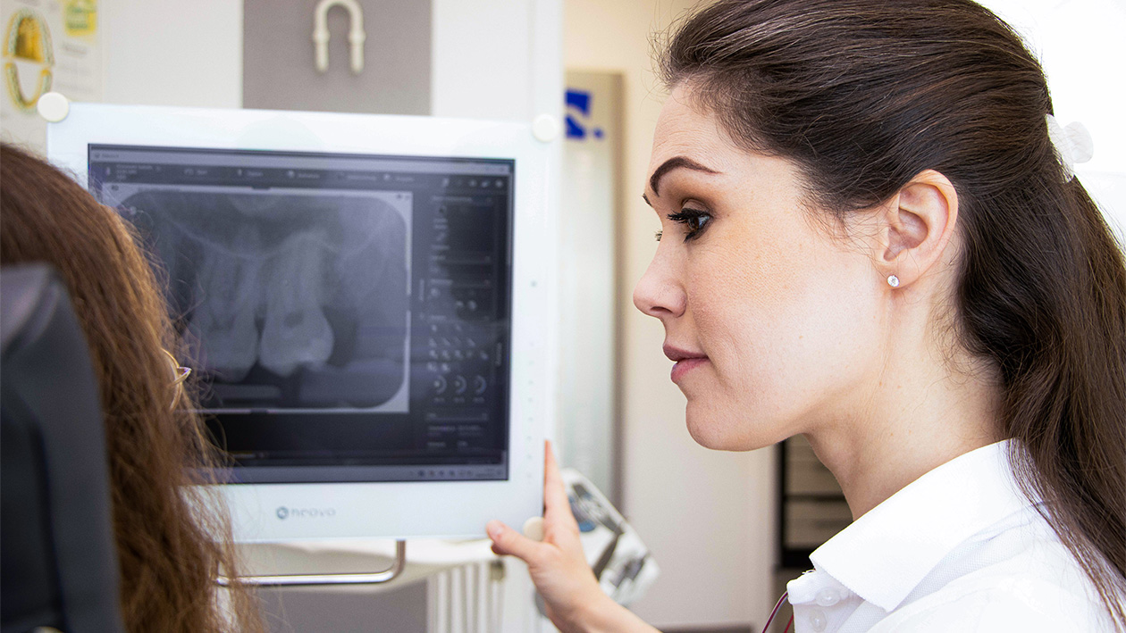 Dr. Isabelle Grünewald zeigt einer Patientin ein Röntgenbild