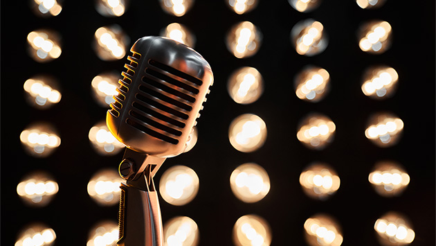 Nahaufnahme eines Mikrofons vor Bühnenlichtern