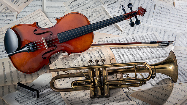 Violine und Trompete liegen auf Notenblättern