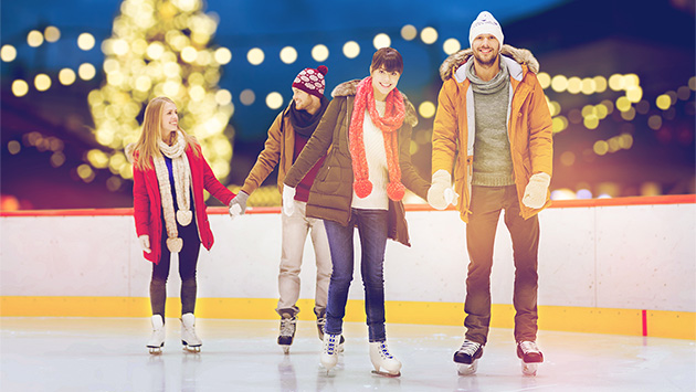 Zwei Paare auf einer weihnachtlichen Schlittschuhbahn