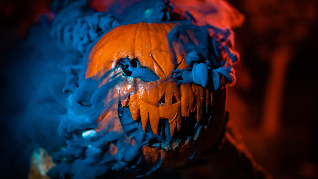 Ein geschnitzter Halloweenkürbis aus dem dunkler Rauch herauskommt