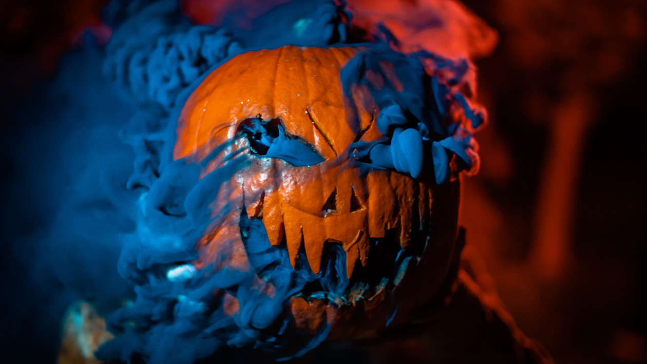 Ein geschnitzter Halloweenkürbis aus dem dunkler Rauch herauskommt
